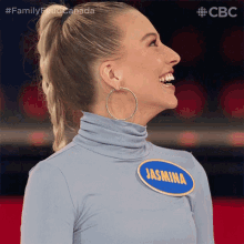 a woman wearing hoop earrings has a name tag that says jasmina