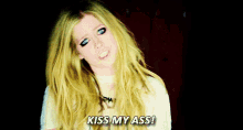 a woman with blonde hair and blue eyes is saying kiss my ass