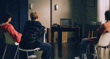 three people are sitting in chairs in front of a television that says ' nbc ' on it
