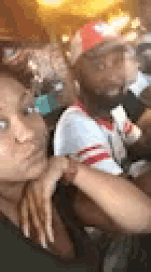 a man and a woman are sitting next to each other and taking a selfie .