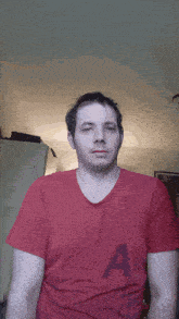 a man in a red shirt is making a face