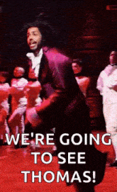 a man is dancing on a stage in front of a group of people .