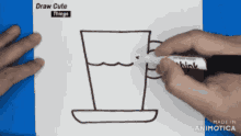 a person is drawing a cup of coffee with a marker on a piece of paper