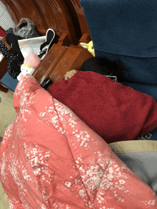 a person laying on a bed with a red blanket on top