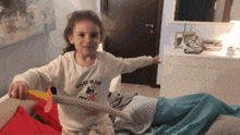 a little girl is holding a toy sword that says young of fun