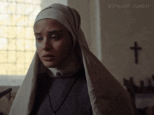 a picture of a nun with a cross in the background