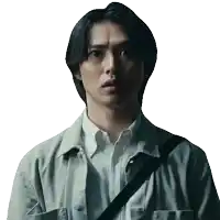 a man wearing a grey jacket and a white shirt has a black strap around his shoulder