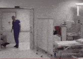 a man in scrubs is walking through a hospital room