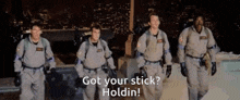 a group of men in ghostbusters uniforms are walking in a line with the words got your stick holdin