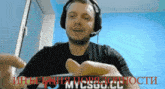 a man wearing headphones is holding something in his hand with the word mycgo.cc written in red