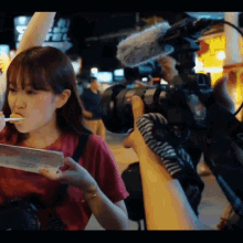 a person holding a camera with a microphone on it