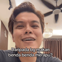 a man is smiling with the words daripada bg makan benda benda merapu on his face
