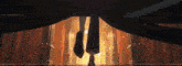 a person is standing in a room with a curtain covering their feet .