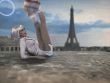 a woman in a white dress is laying on the ground with her legs up in front of the eiffel tower