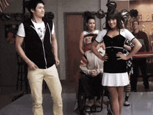 a man in a korg keyboard stands next to a woman in a cheerleading outfit