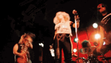 a blurry photo of a group of people on a stage with one of them playing a guitar