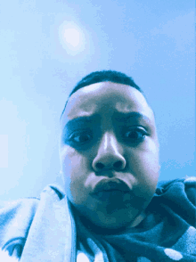 a person with a blue background is making a face