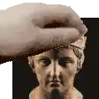 a hand is holding a statue of a man 's head in front of a black background .