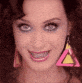 a close up of a woman 's face with braces on her teeth and earrings