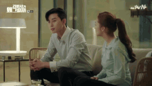 a man and a woman are sitting on a couch and the tvn logo is visible