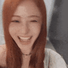 a close up of a woman with red hair smiling and laughing .