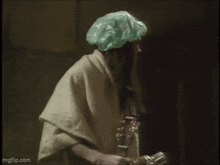 a woman in a bathrobe and surgical cap is saying `` i hate bath night '' while taking a bath .