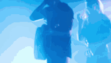 a blurry photo of a man standing in a blue light