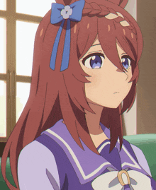 a girl with long brown hair and a blue bow on her hair
