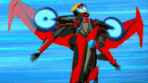 a red and black robot with wings is flying in the sky .