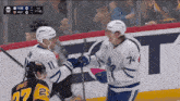 a hockey player with the number 74 on his jersey shakes hands with another hockey player