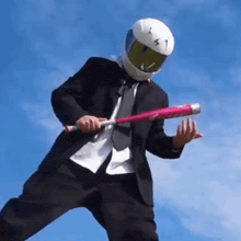 a man wearing a helmet and a suit is holding a baseball bat