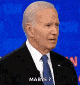 a man in a suit and tie is standing in front of a microphone and asking maybe .