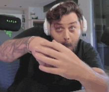 a man wearing headphones with the word razer on the headrest