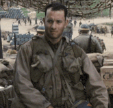 a man in a military uniform is standing in front of a stack of boxes that say fire