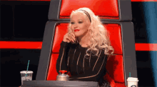 a woman is sitting in a chair with a starbucks cup