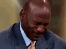 a man in a suit and tie is crying with his mouth open .
