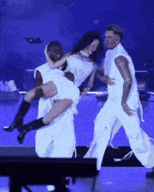 a woman is being lifted in the air by two men