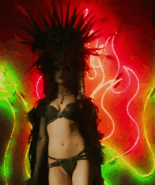 a woman in a bikini stands in front of a neon light