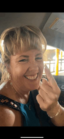 a woman in a blue top is giving the middle finger