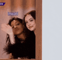 two women peeking out from behind a door with a caption that says ' mwah ' on it