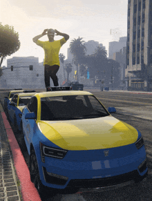 a man is standing on top of a blue and yellow taxi