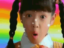a little girl with pigtails has a surprised look on her face .