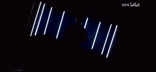 a man wearing glasses and a black shirt is standing in front of a row of lights and the word bilibili is on the bottom