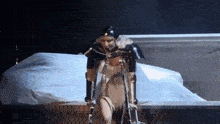 a woman with crutches is standing in front of a bed on a stage .