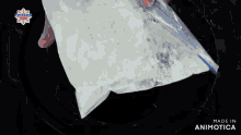 a person is putting something in a plastic bag that says made in animotica on it