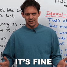 a man stands in front of a white board with the words it 's fine on it