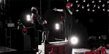 a man in boxing gloves is standing on top of a piano on a stage .