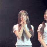 a girl with long hair is making a heart shape with her fingers