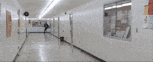 a man in a suit and tie is running down a hallway with posters on the wall