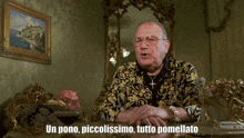 a man sits at a table with the words un pono piccolissimo tutto pomellato written above him
